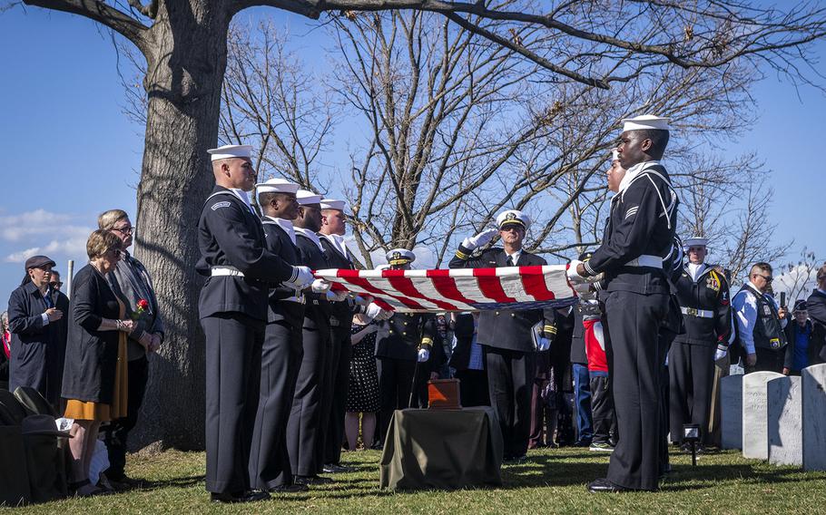 Sailors prepare to meticulously fold into a triangle an American flag that was presented to Gary Bishop and his wife, who traveled from Wyoming to represent the family at the service. 