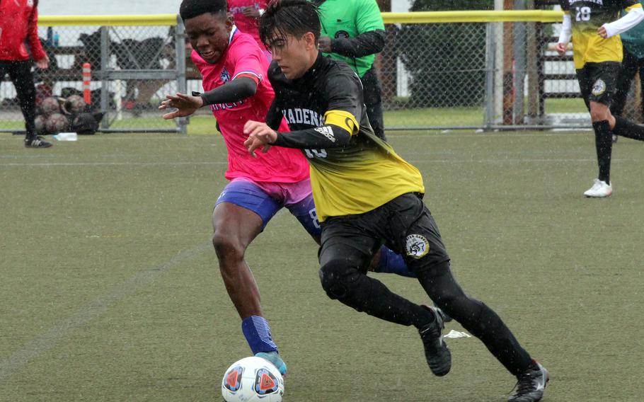 Nile C. Kinnick's Leon Awesso and Kadena's Tyler Smith chase the ball.