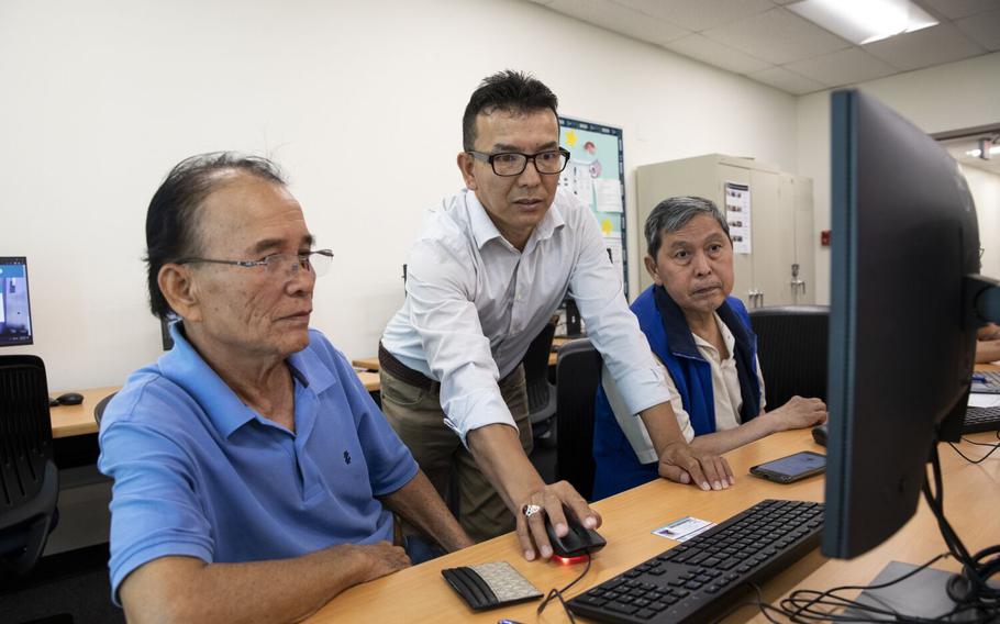 Zulfiqar Noori, center, helps Du Trang, left, and Thanh Vuong with registering for classes at San Diego College of Continuing Education on Thursday, July 20, 2023, in San Diego. Noori is from Afghanistan and resettled in San Diego. He is currently taking classes for cyber security.