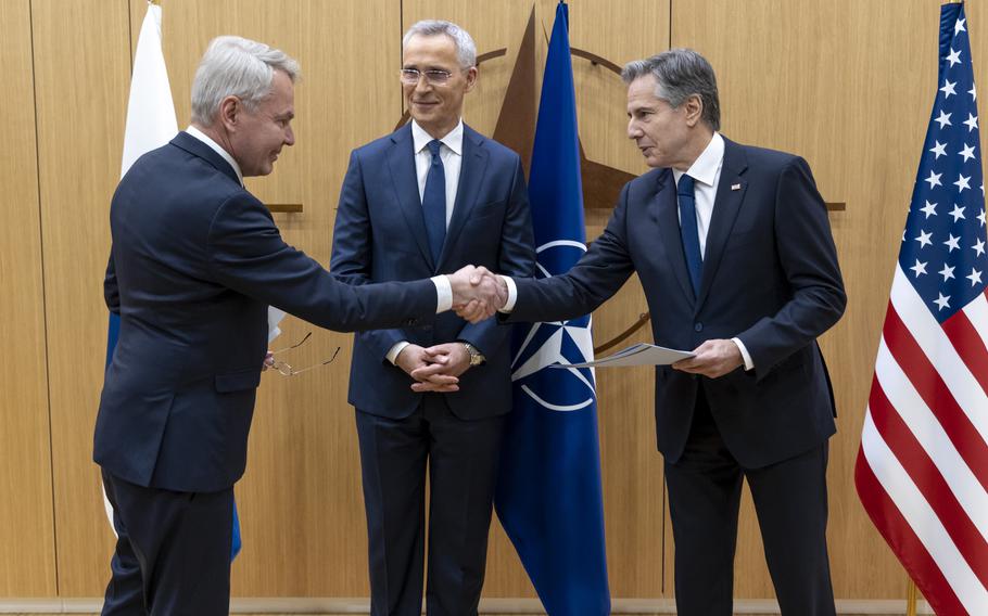 Finnish Foreign Minister Pekka Haavisto, left, shakes hands with U.S. Secretary of State Antony Blinken as NATO Secretary-General Jens Stoltenberg looks on, after Finland signed the instrument of accession to NATO at the alliance headquarters in Brussels, April 4, 2023.