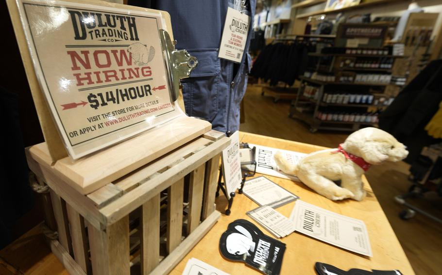 A now hiring sign sits on a display in a clothing store Saturday, Oct. 9, 2021, in Sioux Falls, S.D. The number of Americans applying for unemployment benefits fell to its lowest level since the pandemic began, a sign the job market is still improving even as hiring has slowed in the past two months. (AP Photo/David Zalubowski)