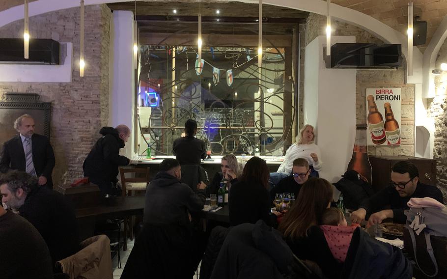 The interior of the original Sorbillo pizzeria in Naples, Italy, features natural stone and wood and is decorated with modern lighting.