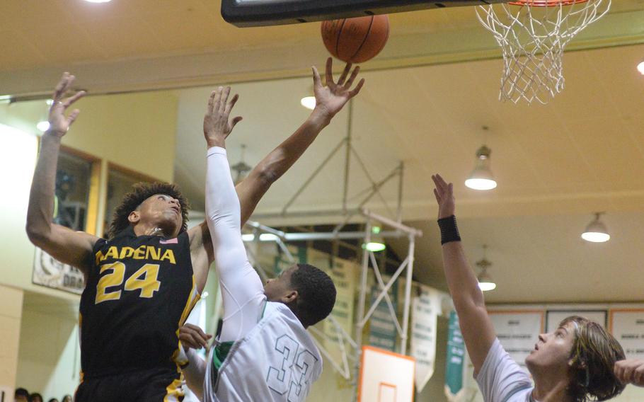 Kadena's Jeremiah Lewis puts up a shot over Kubasaki's Terrence Reese and Ethan Harpuder during Thursday's season-opening Okinawa basketball game. The Panthers won 53-43 with Lewis scoring 31 points and blocking 10 shots.