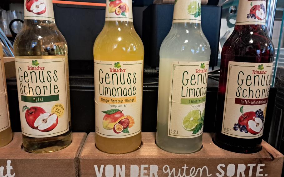 Bottles stacked next to the refrigerator show part of the assortment of fruity beverages offered at Rada Arepa in Heidelberg, Germany. The establishment comprises a restaurant and a cafe with roastery, where coffee beans from Central and South America predominate. 