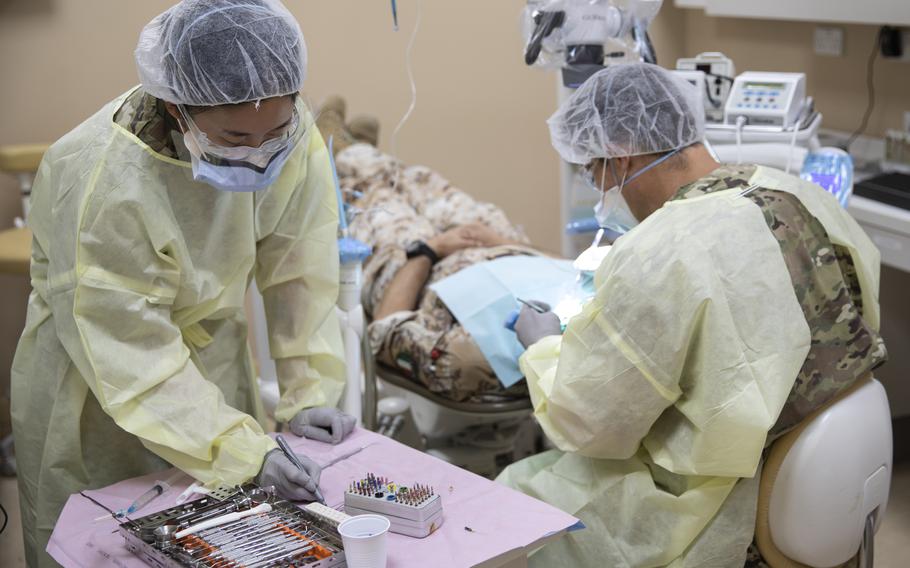 Army Spc. Jiayuan Zhang, a preventive dentistry specialist from the 673rd Dental Company Area Support unit based at Joint Base Lewis-McChord, Wash., records dental information during a root canal on an Italian soldier on Sept. 14, 2020, at Camp Arifjan, Kuwait. 