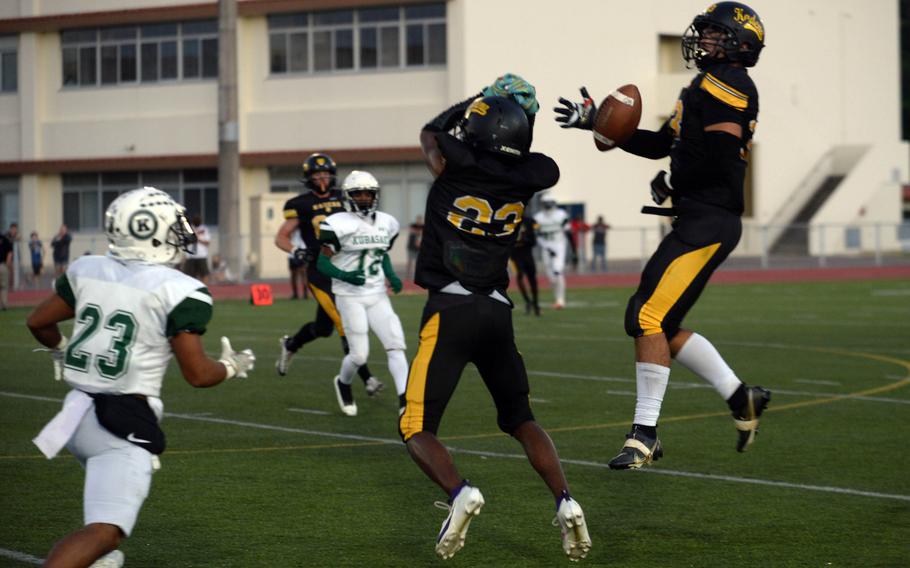 Kadena's Flint Barton, right, tries to intercept but can't quite find the handle on the ball.