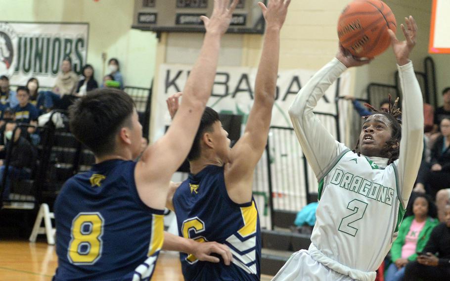 Kubasaki's Carlos Cadet shoots over Taipei American defenders during Friday's inter-district boys basketball game. The Tigers won 61-41.