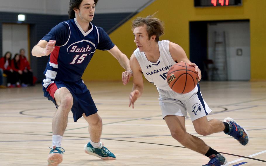 Black Forest Academy’s Kaleb Kroeker drives as Aviano’s Gabe Fabbro defends during the final game of pool play at the Division II DODEA European Basketball Championships at Southside Fitness Center on Ramstein Air Base, Germany.