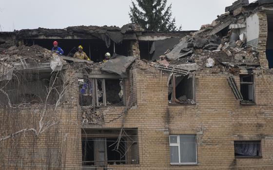Emergency personnel work at the scene following a drone attack in the town of Rzhyshchiv, Kyiv region, Ukraine, Wednesday, March 22, 2023. 
