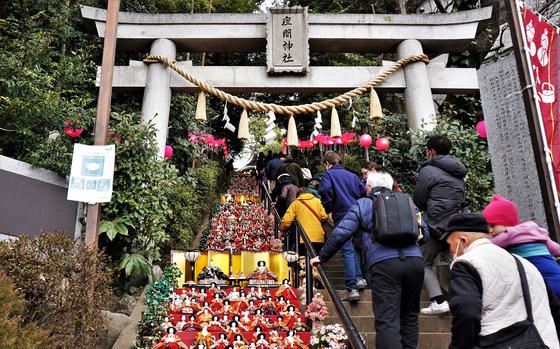 People climb Zama Shrine's steps, decorated with hundreds of ornate dolls, on a Japanese holiday known as Girls' Day, March 3, 2023.
