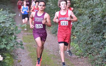 Baumholder's Kipuha Fejeran, left, runs alongside Kaiserslautern's Maxwell Worley during a Sept. 30, 2023, meet at Ramstein High School on Ramstein Air Base, Germany.