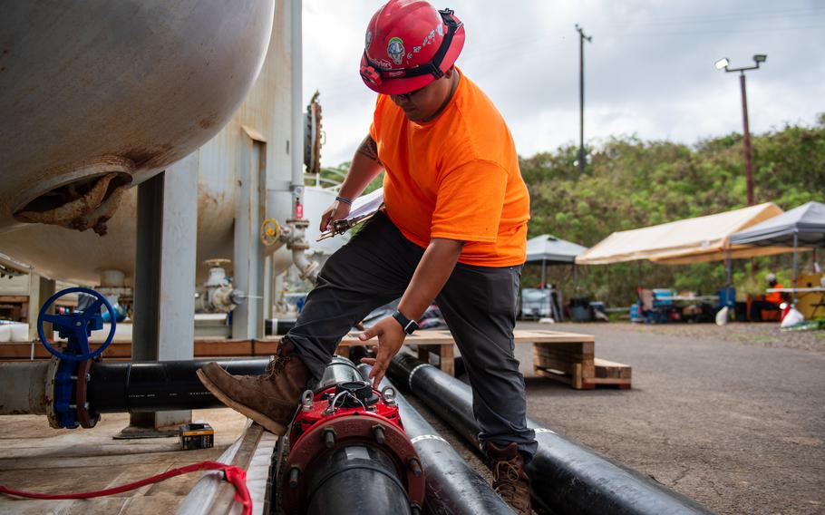 A Navy contractor checks the water flow rate in a carbon-filter system on April 18, 2022, as a part of monitoring at the Navy’s Red Hill well in Hawaii.