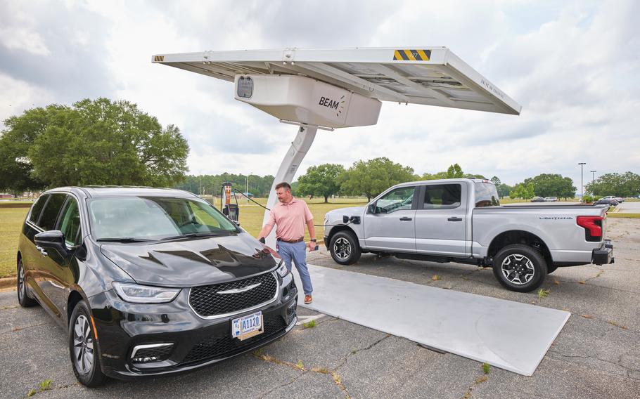 Fleet Manager Zachary Haller uses the charging station to charge two of the base’s electric vehicles.