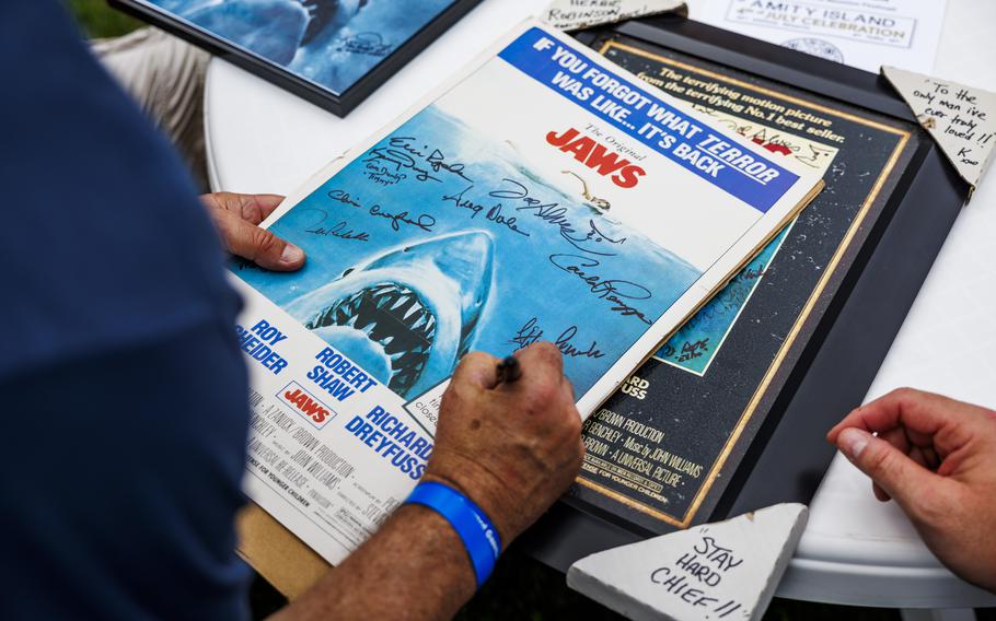 “Jaws” extra Peter Robb autographs a poster. 