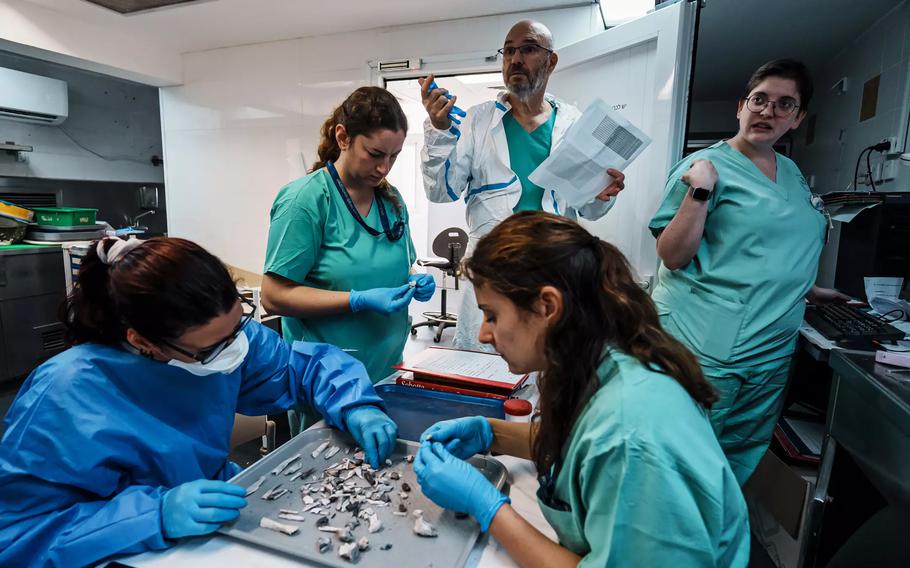 Forensic doctors and volunteers examine remains at the National Institute of Forensic Medicine.