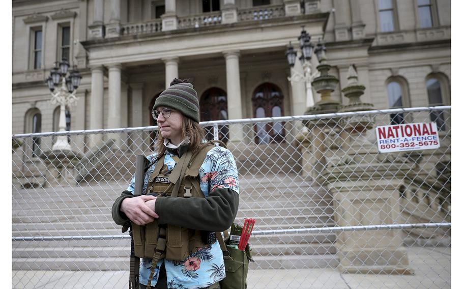 Boogaloo group member Timothy Teagan stands with a rifle at a protest outside the Michigan Capitol on Jan. 17, 2021, in Lansing.