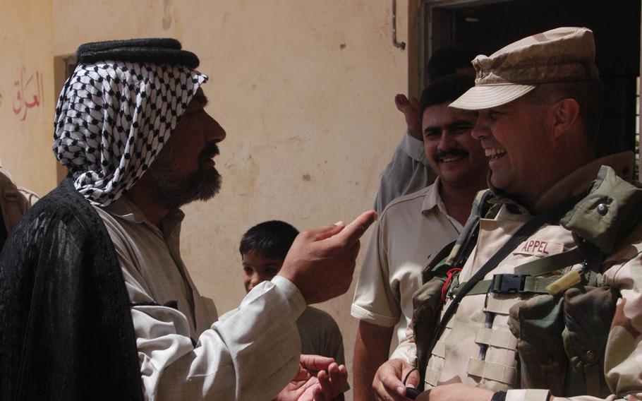 A soldier speaks to local Iraq leaders