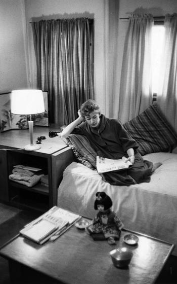A woman reads a book on a bed