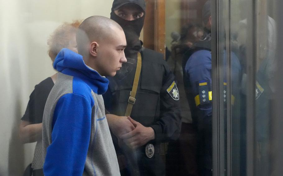 Russian army Sgt. Vadim Shishimarin, 21, is seen behind a glass during a court hearing in Kyiv, Ukraine, Friday, May 13, 2022. The trial of a Russian soldier accused of killing a Ukrainian civilian opened Friday, the first war crimes trial since Moscow’s invasion of its neighbor.