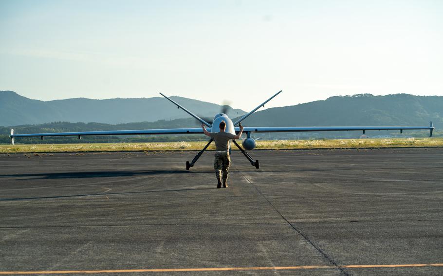 An airman with 319th Expeditionary Reconnaissance Squadron marshals an MQ-9 Reaper from its parking space at Kanoya Air Base of the Japan Maritime Self-Defense Force in Kanoya, Japan, on Nov. 5, 2022. 