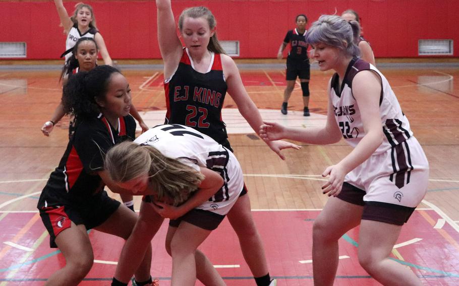 E.J. King's Katelyn Mapa and Zama's Lorelei Holt tie up the ball as Cobras' Madylyn O'Neill and Trojans' Kaitlynn McAbee look to help during Saturday's DODEA-Japan girls basketball game. The Cobras won 70-36.