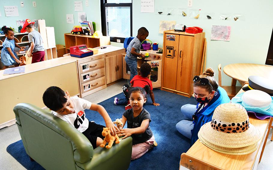 A  child care provider wears a mask while watching over her students.