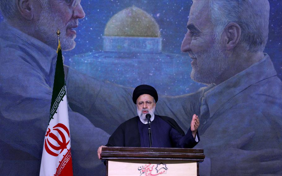 Iran President Ebrahim Raisi speaks during a commemoration ceremony marking the anniversary of the 2020 killing of Guards general Qasem Soleimani (on screen right) and Iraqi commander Abu Mahdi al-Muhandis (on screen left) in Tehran on Jan. 3, 2024. 