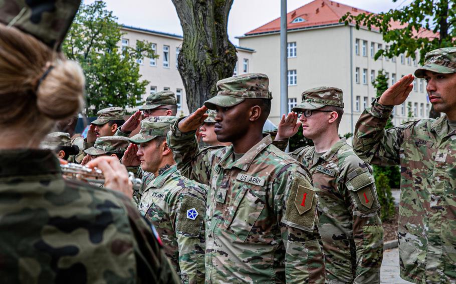 U.S. soldiers salute the flag during a base renaming ceremony at Poznan, Poland, July 30, 2022. Forward Operating Site Poznan was renamed Camp Kosciuszko, making it the permanent U.S. Army garrison in the country. The proposed National Defense Authorization Act would essentially void parts of a 26-year-old agreement with Russia that put certain limits on how troops are deployed in former Soviet states.