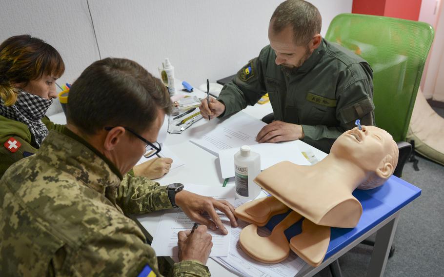 Ukrainian military medics take an exam that would allow them to instruct others on combat first aid on Oct. 27, 2022, at a training site outside Kyiv, Ukraine. Medics rotate back to Kyiv so they can share combat experience from the front lines with new soldiers and civilians. 