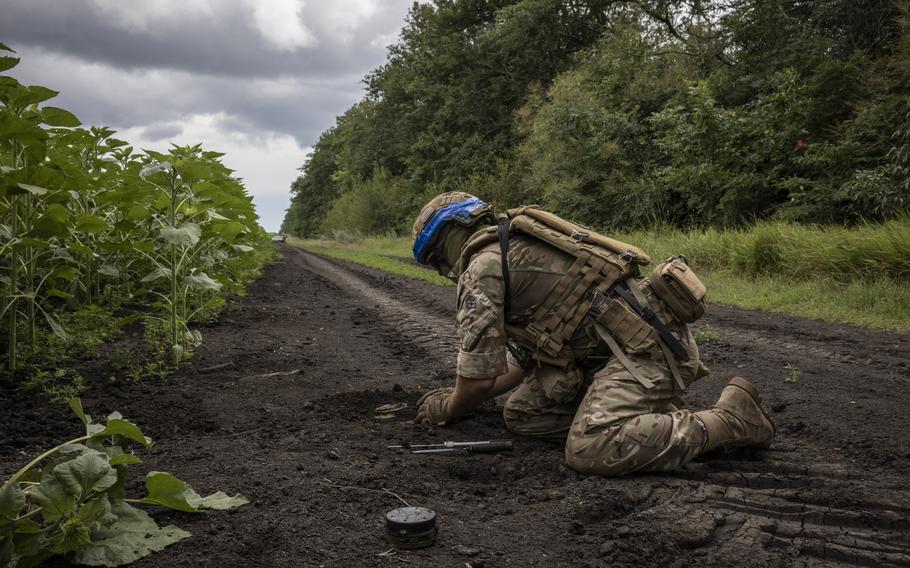 A soldier uncovers an antitank mine during a mine clearance exercise in the Dnipropetrovsk region of Ukraine on July 11. 