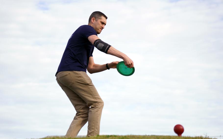 Air Force Maj. Marshall Gries makes a disc-golf tee shot on the Par 3 course at Yokota Air Base, Japan, April 6, 2023.