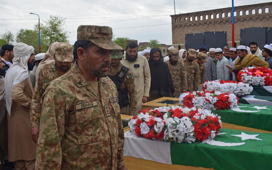 Relatives and security officials gather around the coffins of policemen who were killed by a roadside bomb in Lakki Marwat district of Khyber Pakhtunkhwa province on March 30, 2023.