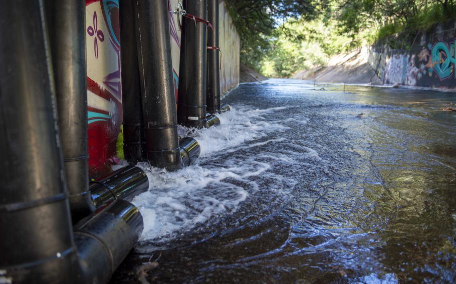 Water pumped from the Red Hill well in Aiea, Hawaii, and purified through carbon filters, is discharged into the Halawa Stream on Jan. 30, 2022.