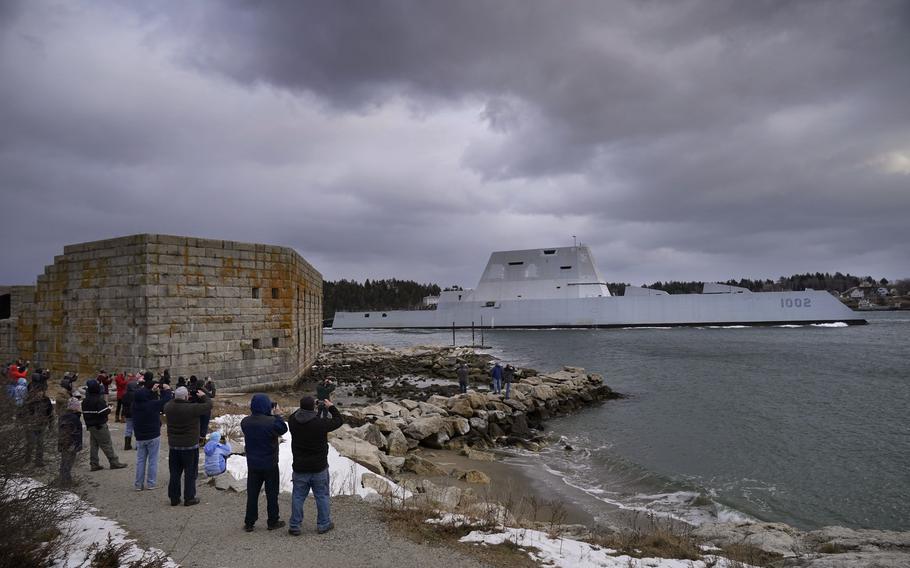 Spectators watch as the USS Lyndon B. Johnson passes Fort Popham on its way to sea, on Wednesday, Jan. 12, 2022, in Phippsburg, Maine. The warship was the third and final Zumwalt-class destroyer built for the Navy at Bath Iron Works.