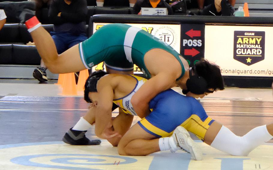 John F. Kennedy 145-pounder Malcom Lim gets the upper hand on Guam High's Chris Angoco during Saturday's Guam wrestling quad-meet. Lim won the bout between two former iisland champions by decision 3-2, but the Panthers won the meet 54-14.