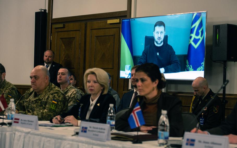 International defense officials listen to a video message from Ukrainian President Volodymyr Zelenskyy during the Ukraine Defense Contact Group meeting on Friday, Jan. 20, 2023, at Ramstein Air Base, Germany. Zelenskyy expressed thanks for continued support but said new commitments will be needed for Ukraine to continue its fight against Russia.