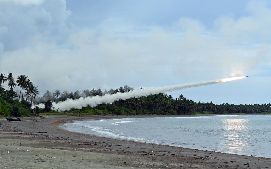 U.S. soldiers fire a High Mobility Artillery Rocket System over the coast.