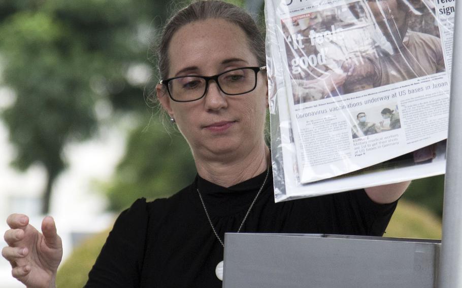 Leslie Jones, the 374th Airlift Wing historian, places Stars and Stripes newspapers into a time capsule at Yokota Air Base, Japan, Thursday, July 29, 2021.