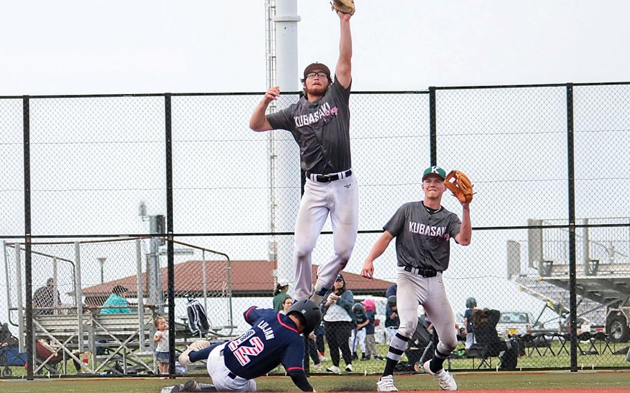 Kubasaki's Lukas Gaines skies for the ball as Kadena's Ty Lujan slides into second.