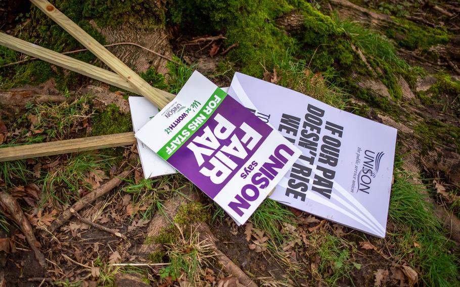 Placards sit on the ground during a strike action by ambulance workers near Central Ambulance Station in Manchester, England, on Wednesday, Jan. 11. Members of two unions, Unison and the GMB, are walking out as part of an ongoing row over real-terms pay cuts suffered by staff in the National Health Service. 