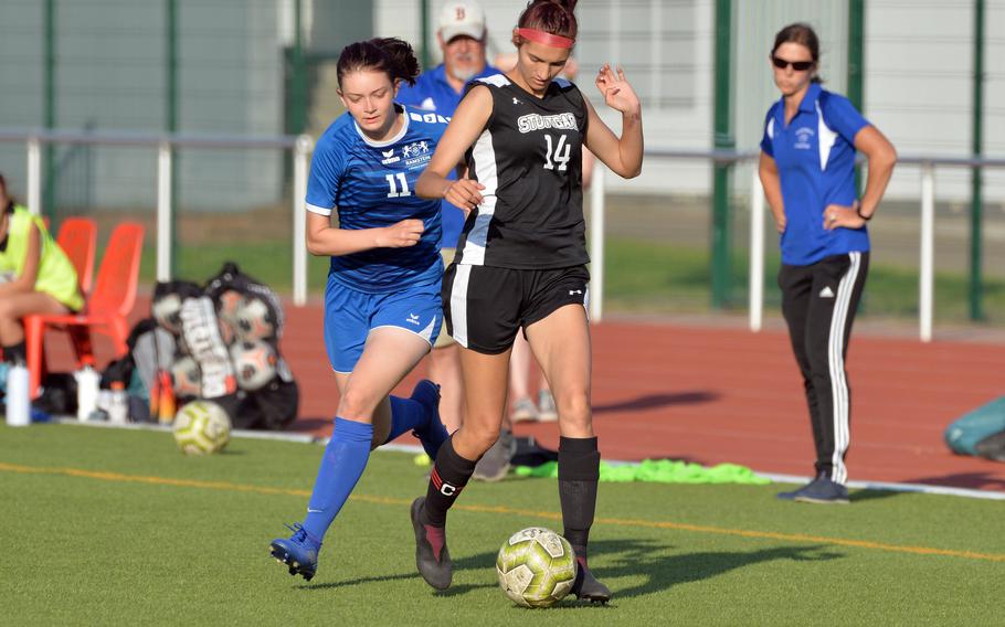 Ramstein’s Alyss Nichols, left, tries to take the ball from Stuttgart’s Kendall Boudreaux in the girls Division I final at the DODEA-Europe soccer championships in Kaiserslautern, Germany, Thursday, May 19 2022. The game ended 1-1 and the teams were named co-champions after a lightning storm stopped the game.