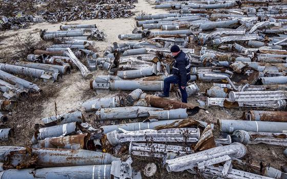 This aerial picture taken on December 7, 2022, shows an expert of the prosecutor's office examining collected remnants of shells and missiles used by the Russian army to attack the second-largest Ukrainian city of Kharkiv, amid the Russian invasion of Ukraine. (ALEKSEY FILIPPOV/AFP via Getty Images/TNS)