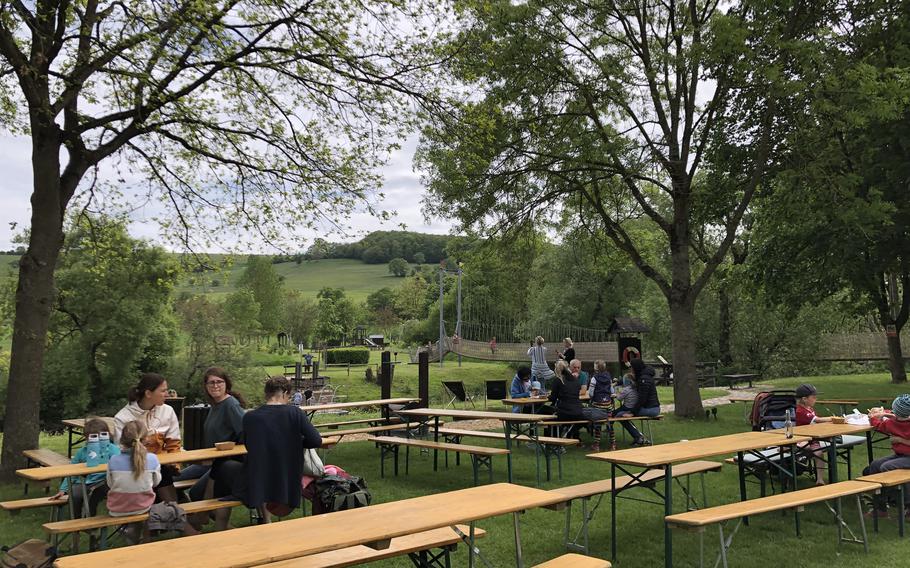Hikers take a break at the beer garden and refreshment stand along the Nahe River at the barefoot park in Bad Sobernheim, Germany.