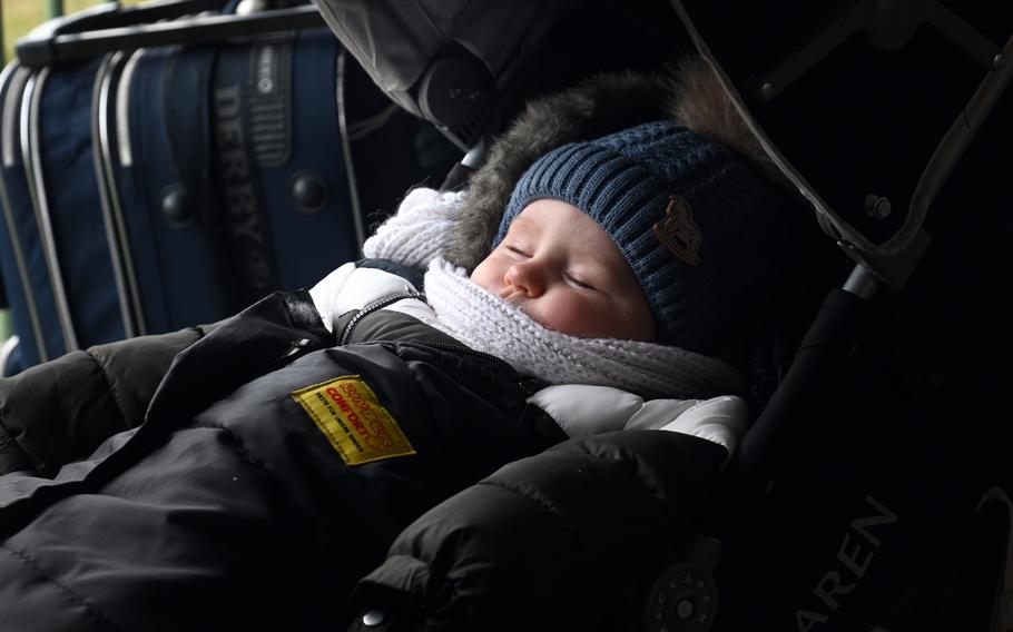 A baby sleeps through the commotion at the Przemysl, Poland, as refugees arrive from Ukraine, March 2, 2022.