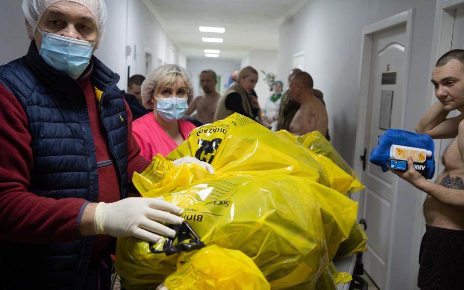 Hospital workers collect the clothes of freed Ukrainian prisoners of war, to be sent for analysis as potential evidence of war crimes.
