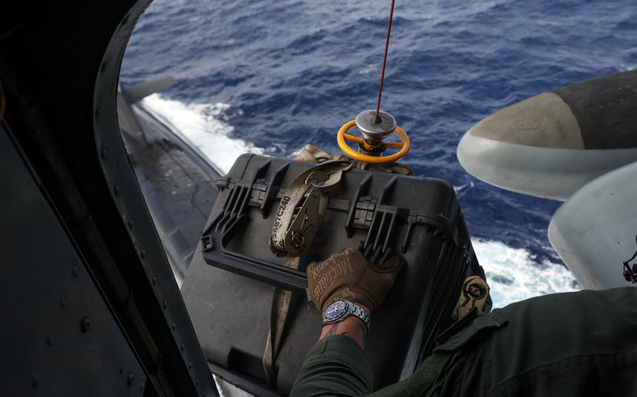 Aboard a CH-53E Super Stallion, Staff Sgt. Joseph McDonnell, a crew chief with Marine Heavy Helicopter Squadron 462, lowers supplies to the Ohio-class ballistic missile submarine USS Maine in the Philippine Sea, May 9, 2023.