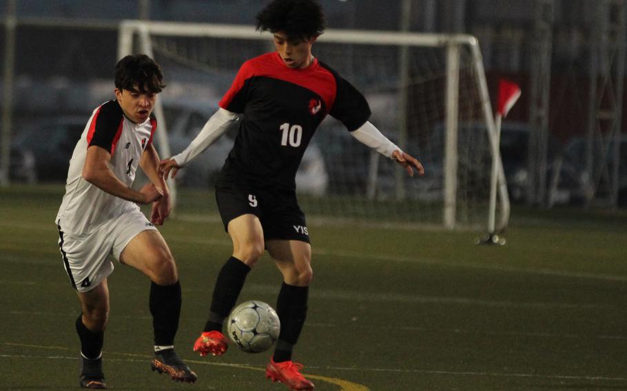 Nile C. Kinnick's Kevin Serrano and Yokohama International's Aoi Ita chase the balll during Wednesday's boys soccer match. Kinnick won 4-2.