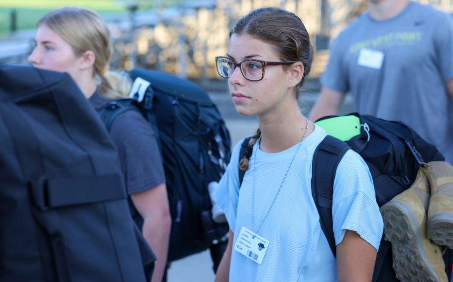 A cadet with a backpack walks onto campus.