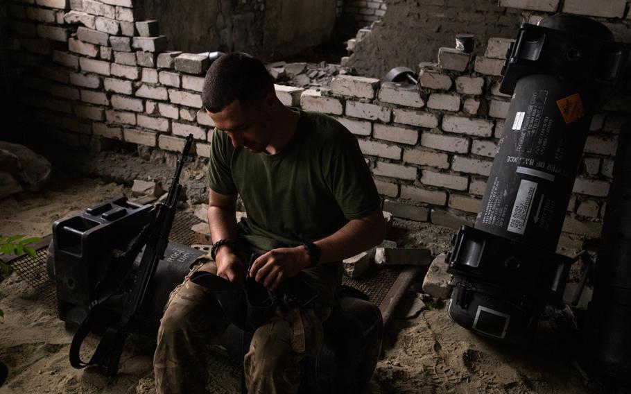 A Ukrainian soldier, who identified himself by his call sign, Stus, sits on an empty Javelin missile container near the front lines on July 21. Ukrainian soldiers are using the empty containers for several purposes, including sleeping. 