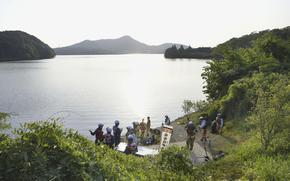 Firefighters gather for a search operation as a Japanese air force plane crashed after taking off for a training flight, at a pond in Inuyama, central Japan, Wednesday, May 14, 2025. (Kyodo News via AP)